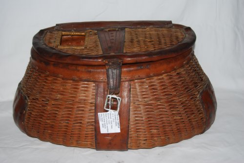 VINTAGE ANTIQUE TURTLE LEATHERED FISHING CREEL. Woven of split bamboo. 16 in. long X 8 in. high. Side Hole, Trimmed in Leather. Marked on base leather strap:Ilhan New Boulder Colo. SOLD